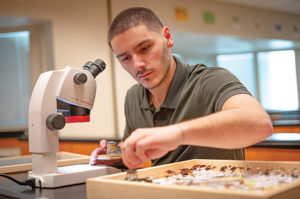Former OBHC resident working with a microscope